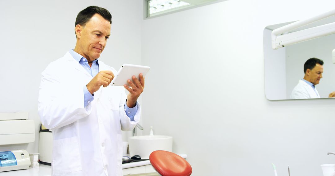 Dentist Using Tablet in Modern Dental Clinic - Free Images, Stock Photos and Pictures on Pikwizard.com