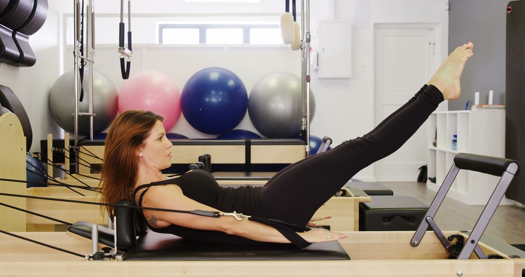 Woman Exercising with Pilates Reformer in Fitness Studio - Free Images, Stock Photos and Pictures on Pikwizard.com