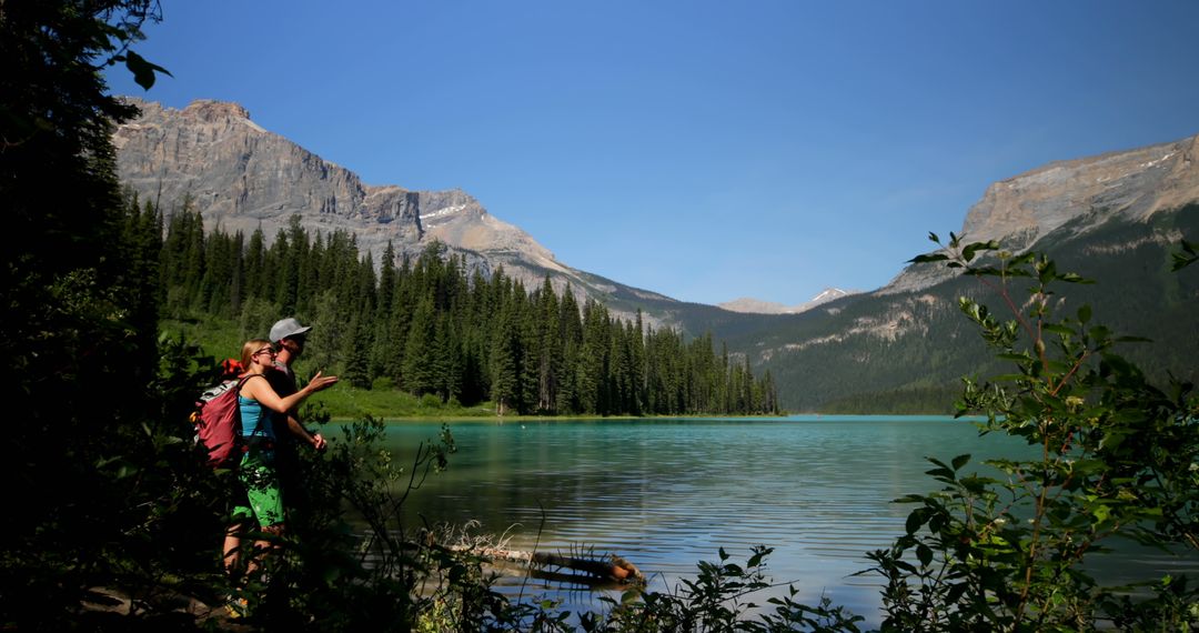 Hikers Explores Calm Lake in Mountain Landscape - Free Images, Stock Photos and Pictures on Pikwizard.com