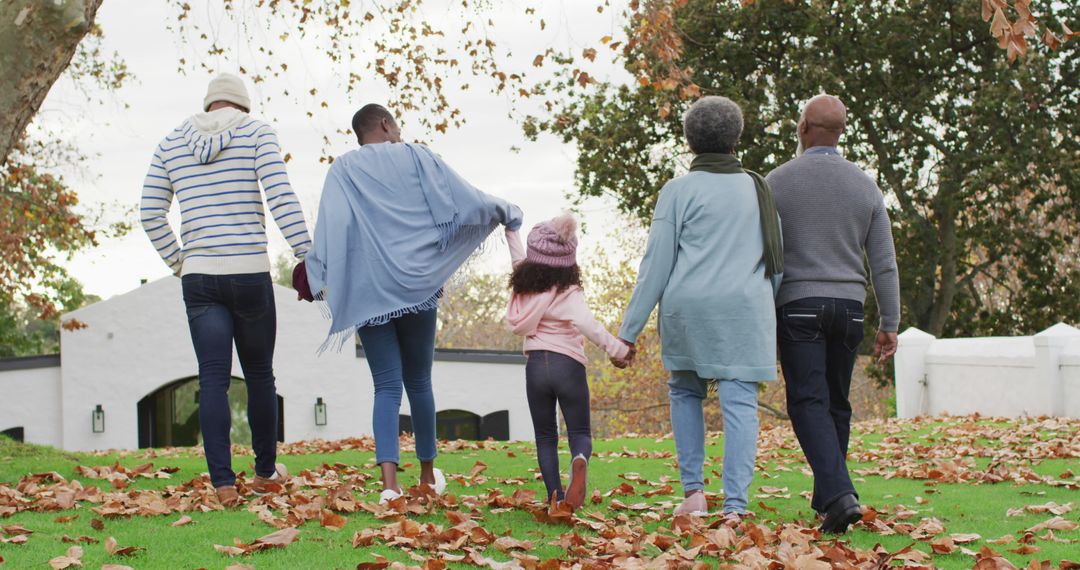 Image of rear view of african american parents and grandparents and granddaughter walking in garden - Free Images, Stock Photos and Pictures on Pikwizard.com