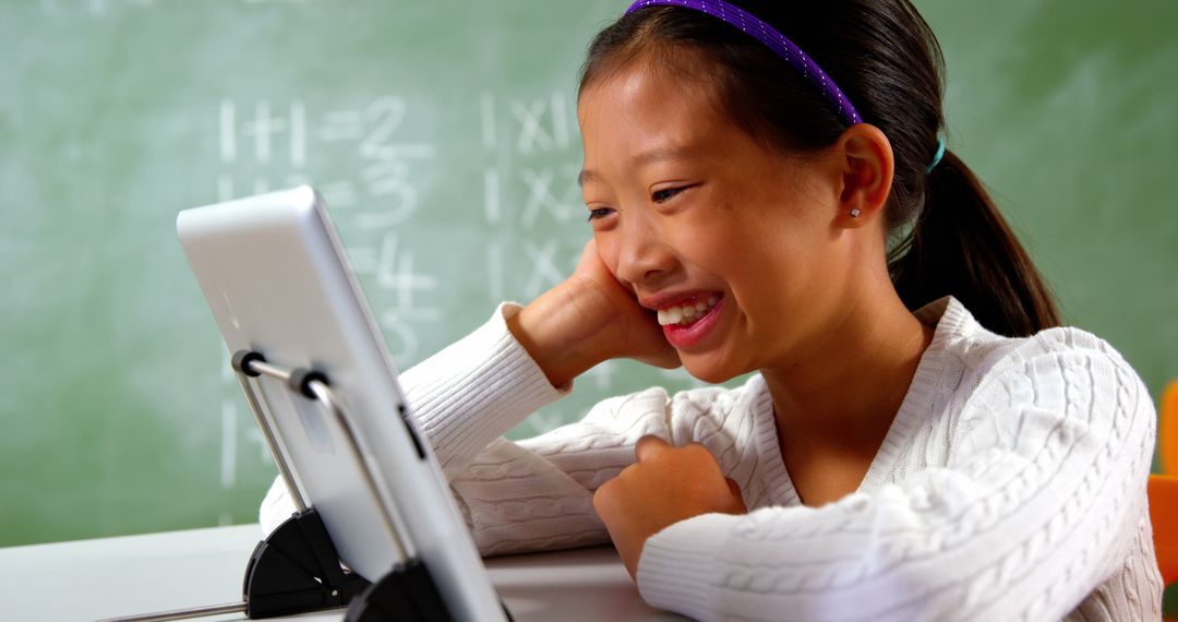 Smiling Schoolgirl Engaged with Tablet in Classroom - Free Images, Stock Photos and Pictures on Pikwizard.com