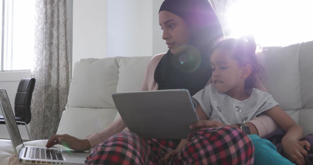 Mother and Daughter Engaging with Technology on Sofa