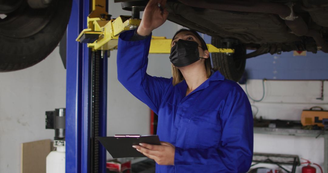 Female mechanic inspecting car undercarriage at auto repair shop - Free Images, Stock Photos and Pictures on Pikwizard.com