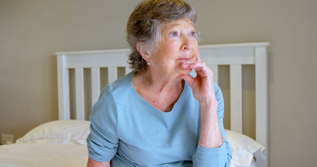 Contemplative Senior Woman Sitting on Bed at Home - Free Images, Stock Photos and Pictures on Pikwizard.com