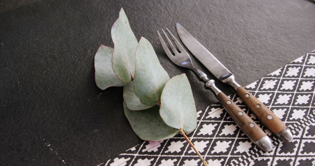 A vintage cutlery and eucalyptus table setting evokes a simple, eco-conscious dining vibe. - Free Images, Stock Photos and Pictures on Pikwizard.com