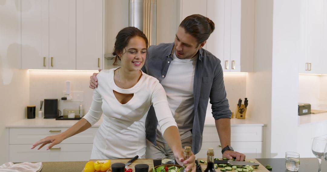Couple Enjoys Fresh Salad Preparation in Modern Kitchen