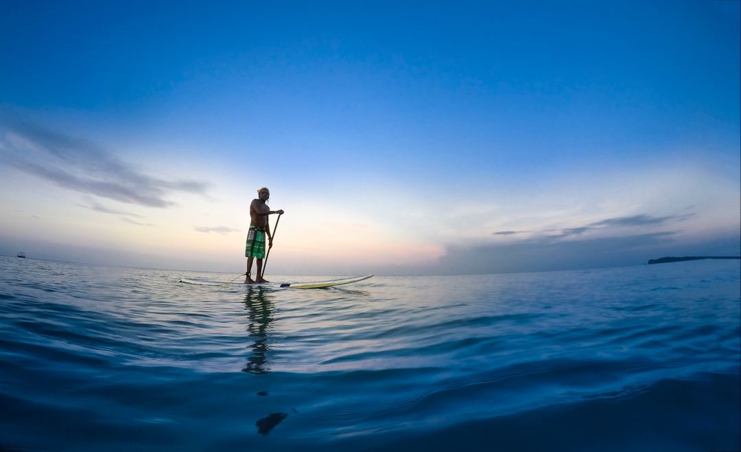 Man Paddleboarding at Sunset on Calm Ocean Water - Free Images, Stock Photos and Pictures on Pikwizard.com