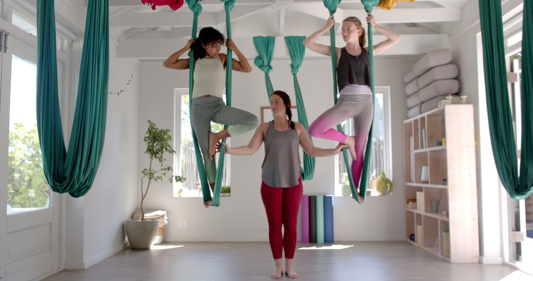 Instructor Teaching Aerial Yoga to Students in Bright Studio - Free Images, Stock Photos and Pictures on Pikwizard.com