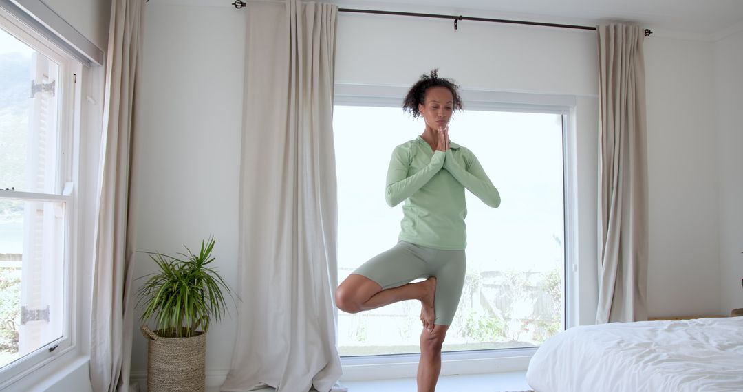 Woman Practicing Yoga by Bedroom Window with Natural Light