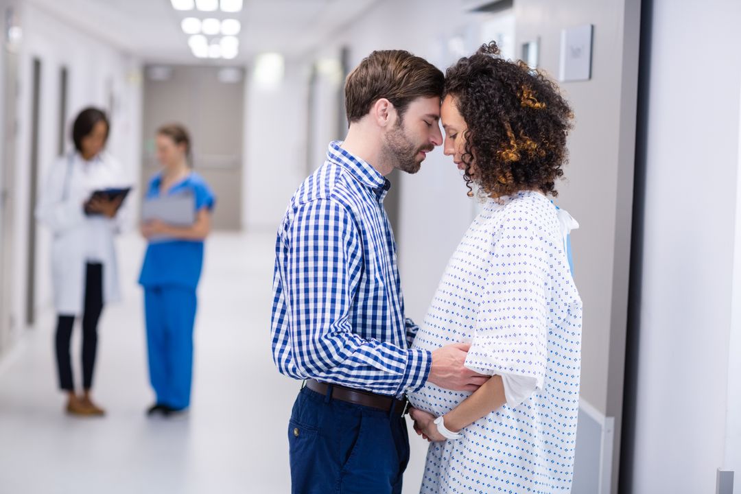 Man Comforting Pregnant Woman in Hospital Corridor - Free Images, Stock Photos and Pictures on Pikwizard.com