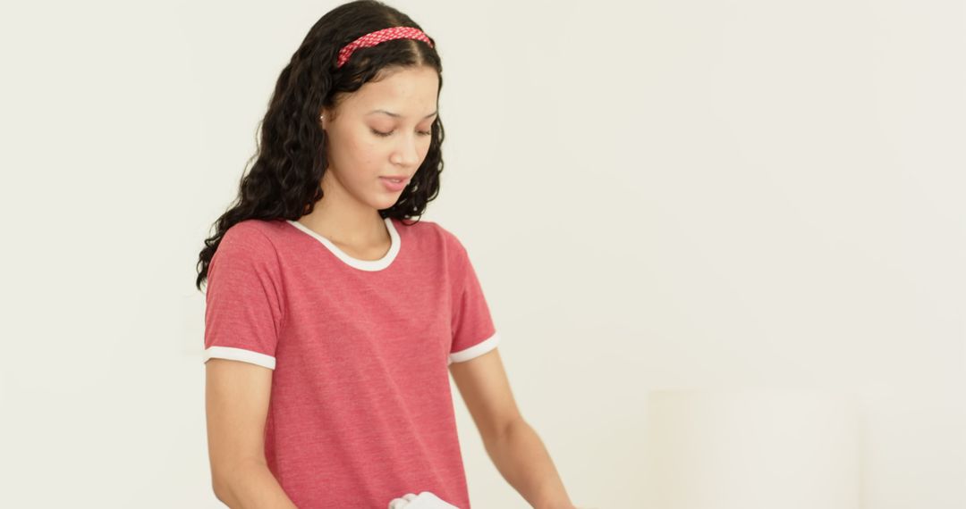 Mother Folding Laundry with Playful Child at Home