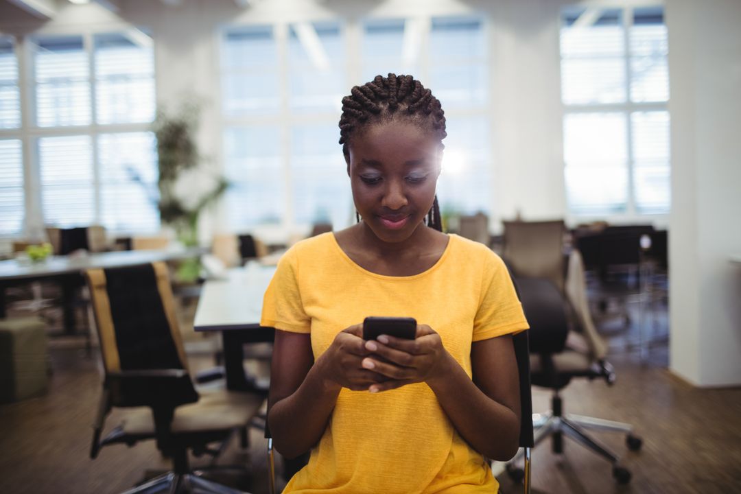 Professional Woman Engaging with Smartphone in Modern Office Space