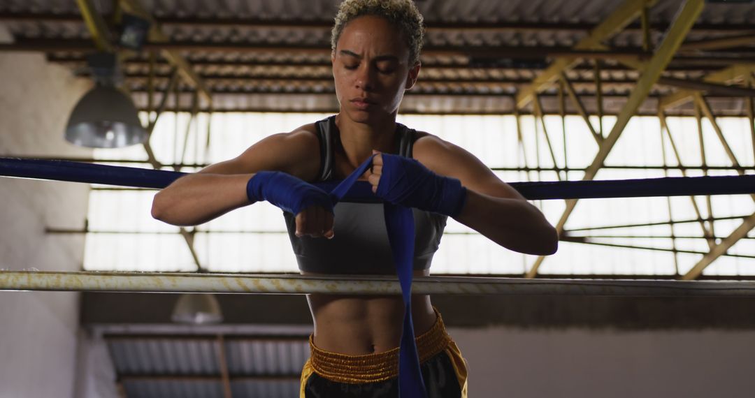 Focused Female Boxer Wrapping Hands in Gym - Free Images, Stock Photos and Pictures on Pikwizard.com