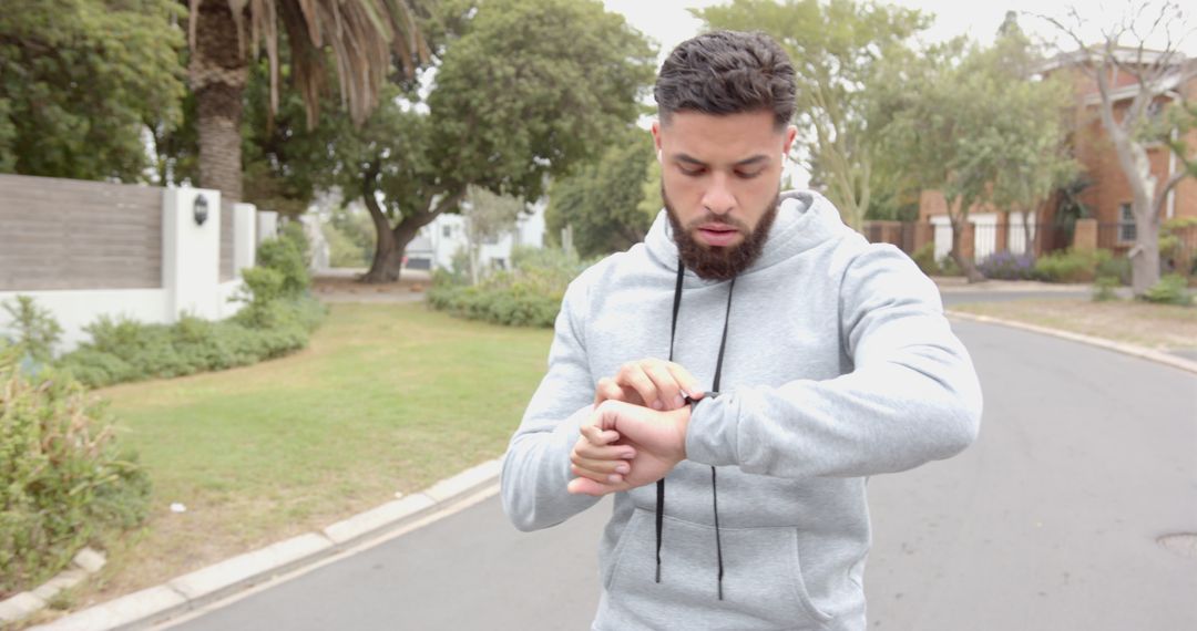 Man Checking Smartwatch in Suburban Street