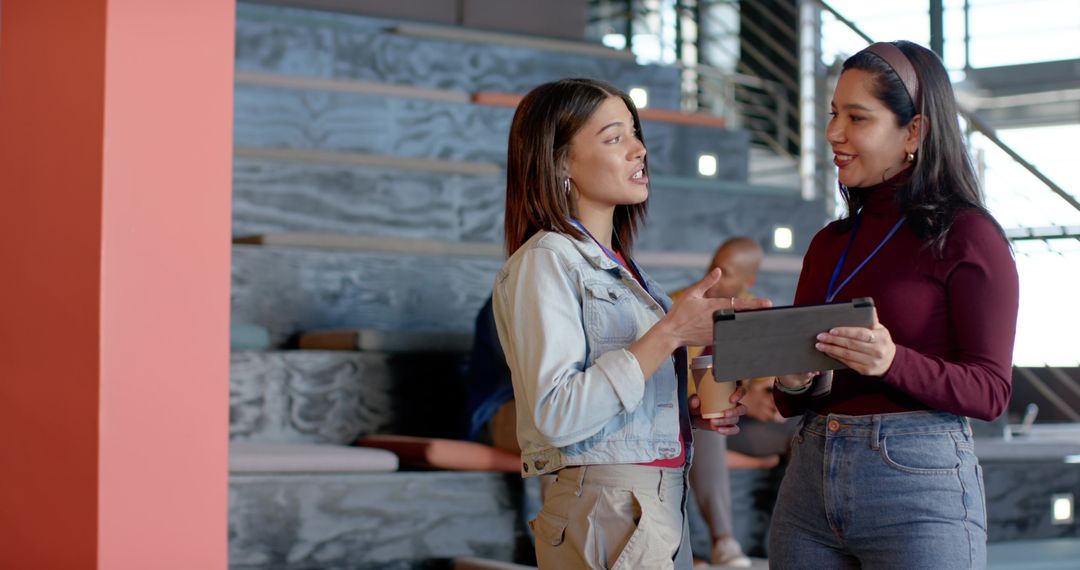 Diverse Colleagues Discussing Project on Tablet in Bright Coworking Space