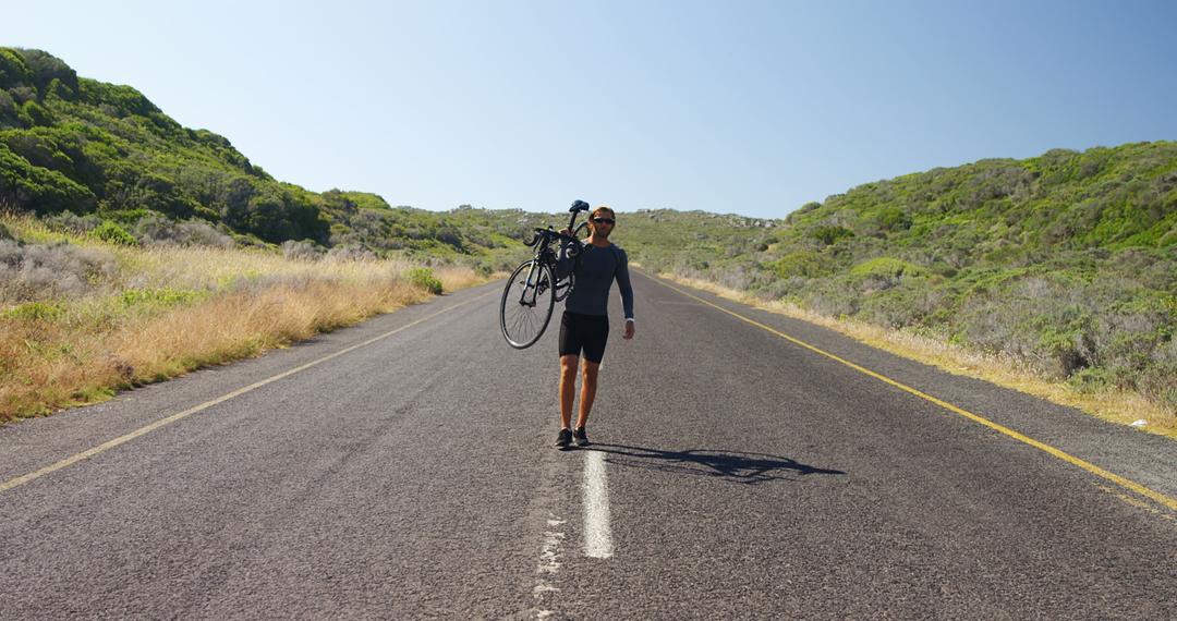 Cyclist Carrying Bicycle on Empty Road in Rural Area - Free Images, Stock Photos and Pictures on Pikwizard.com