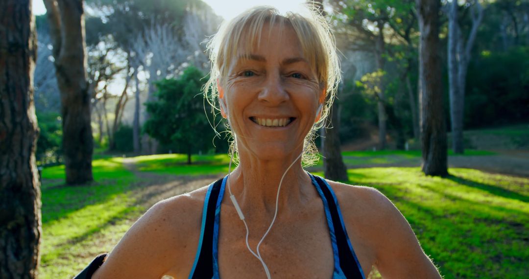 Smiling Mature Woman Exercising in Park with Earbuds - Free Images, Stock Photos and Pictures on Pikwizard.com