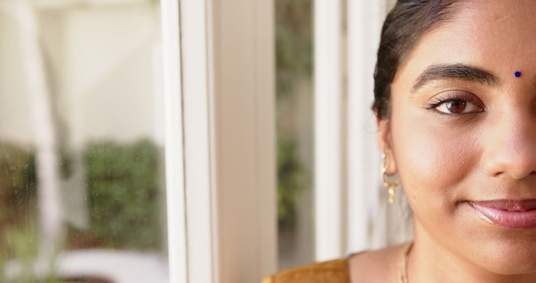 Smiling Woman with Traditional Indian Bindi by Sunlit Window