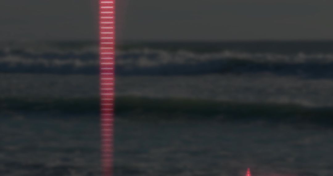 Luminous Red Beam Reflecting on Ocean Waves at Night