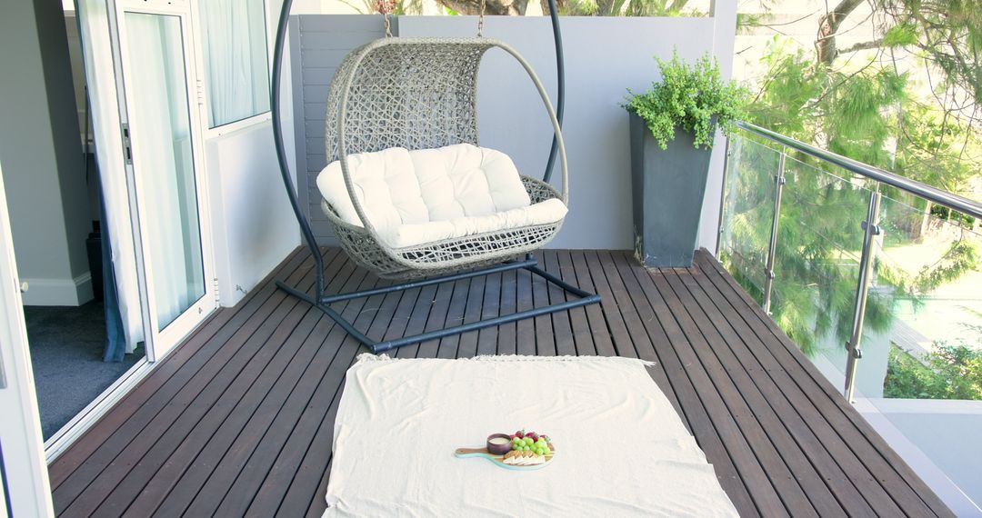 Cozy Balcony Picnic Setup with Modern Hanging Chair