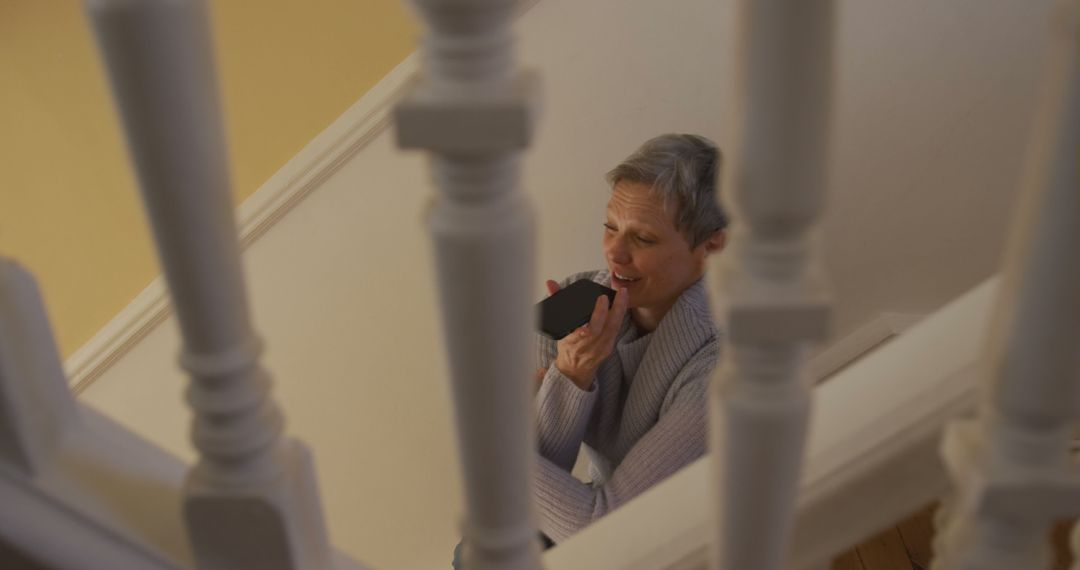 Senior Woman Using Smartphone Through Stair Railing at Home - Free Images, Stock Photos and Pictures on Pikwizard.com