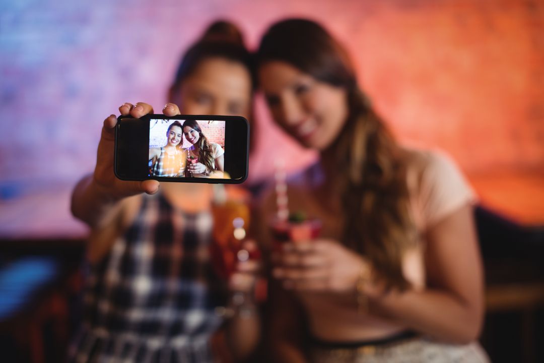 Young women taking a selfie while having cocktail drinks - Free Images, Stock Photos and Pictures on Pikwizard.com