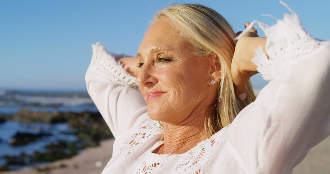 Happy Senior Woman Relaxing on Beach at Sunset - Free Images, Stock Photos and Pictures on Pikwizard.com