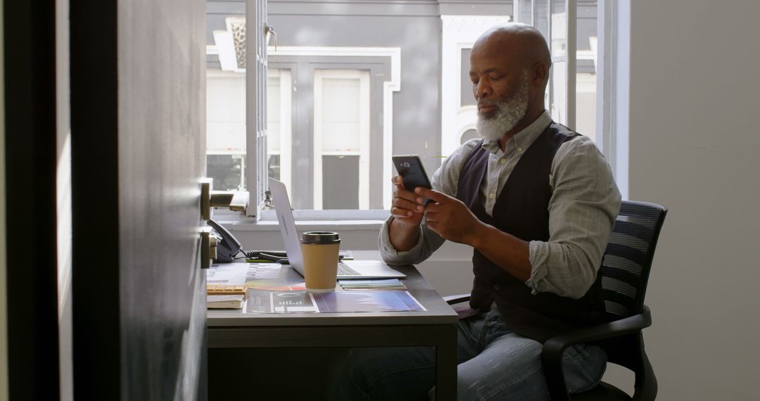 Mature African American Man Working on Smartphone at Desk - Free Images, Stock Photos and Pictures on Pikwizard.com