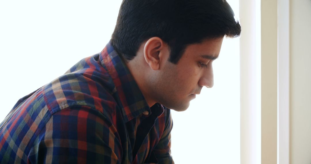 Thoughtful Young Asian Man in Profile Pose with Copy Space