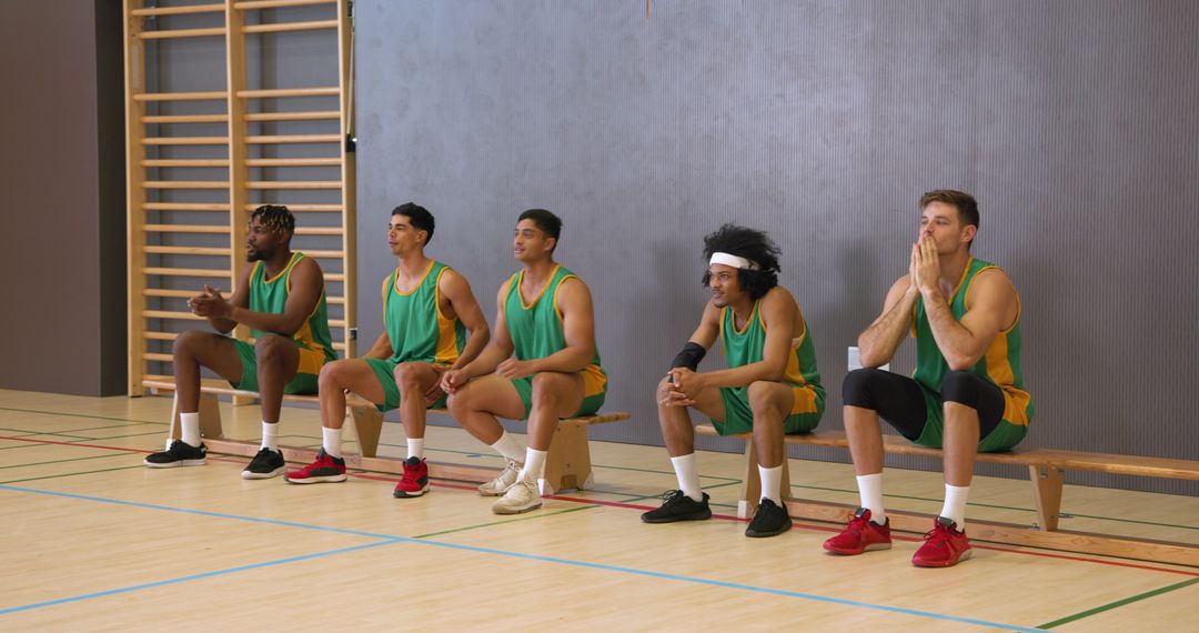 Diverse Basketball Team Sitting on Sideline Bench Preparing for Game