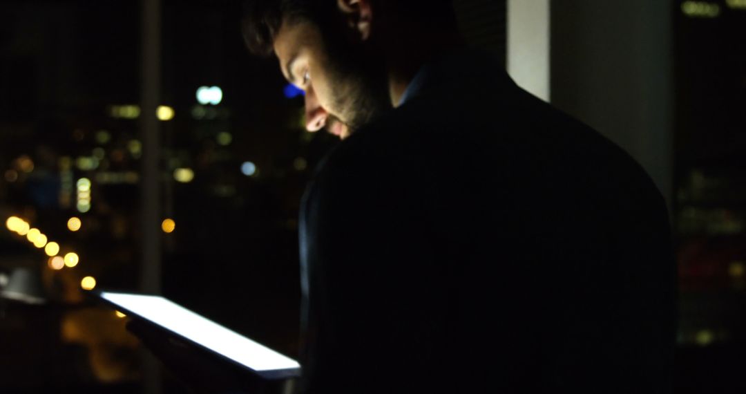 Businessman Working Late on Digital Tablet in Dark Office - Free Images, Stock Photos and Pictures on Pikwizard.com