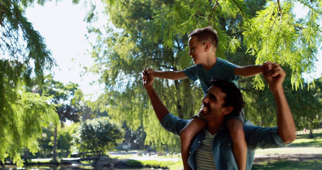 Cheerful Father Giving Son Piggyback Ride in Park Playground - Free Images, Stock Photos and Pictures on Pikwizard.com