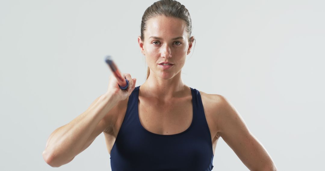 Caucasian Female Athlete Holding Javelin in Studio Setting