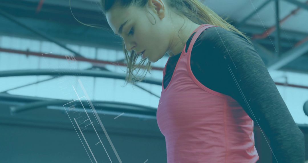 Focused Female Athlete Analyzing Workout Data in Modern Gym