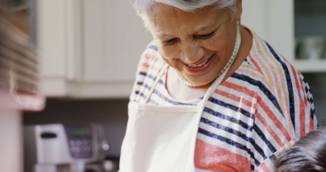 Senior Woman Wearing Apron Cooking at Home with Grandchild - Free Images, Stock Photos and Pictures on Pikwizard.com