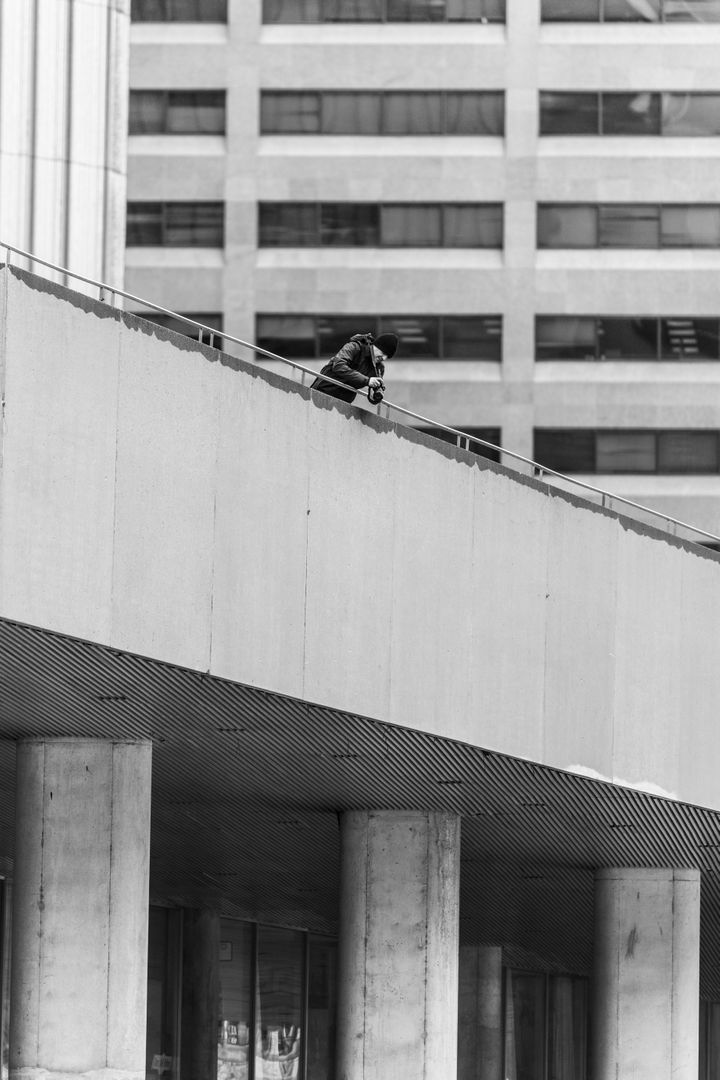 Person Photographing from Elevated Pathway in Urban City - Free Images, Stock Photos and Pictures on Pikwizard.com