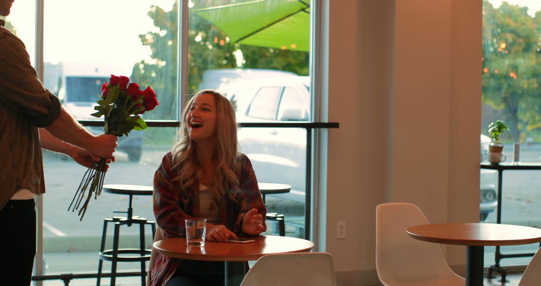 Woman Happily Receiving Bouquet of Roses in Modern Cafe - Free Images, Stock Photos and Pictures on Pikwizard.com