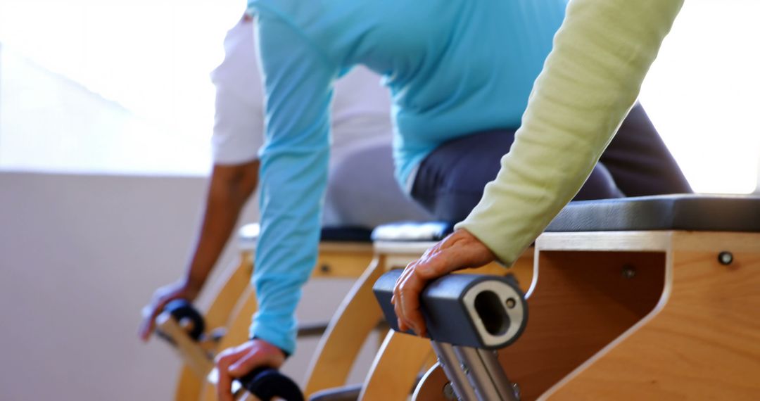 Individuals Using Pilates Equipment in Fitness Studio - Free Images, Stock Photos and Pictures on Pikwizard.com