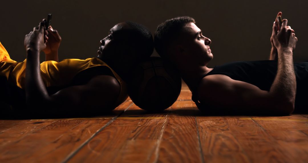 Basketball Players Relaxing with Smartphones on Court - Free Images, Stock Photos and Pictures on Pikwizard.com