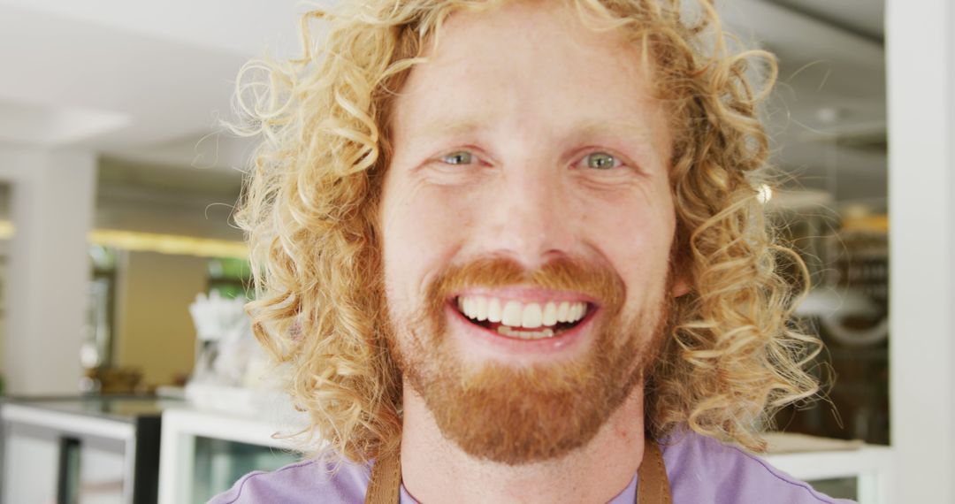 Smiling Curly-haired Man with T-shirt in Modern Cafe - Free Images, Stock Photos and Pictures on Pikwizard.com