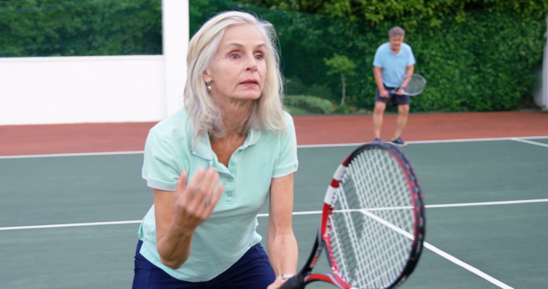 Senior Woman Playing Tennis on Outdoor Court Focused on Game - Free Images, Stock Photos and Pictures on Pikwizard.com