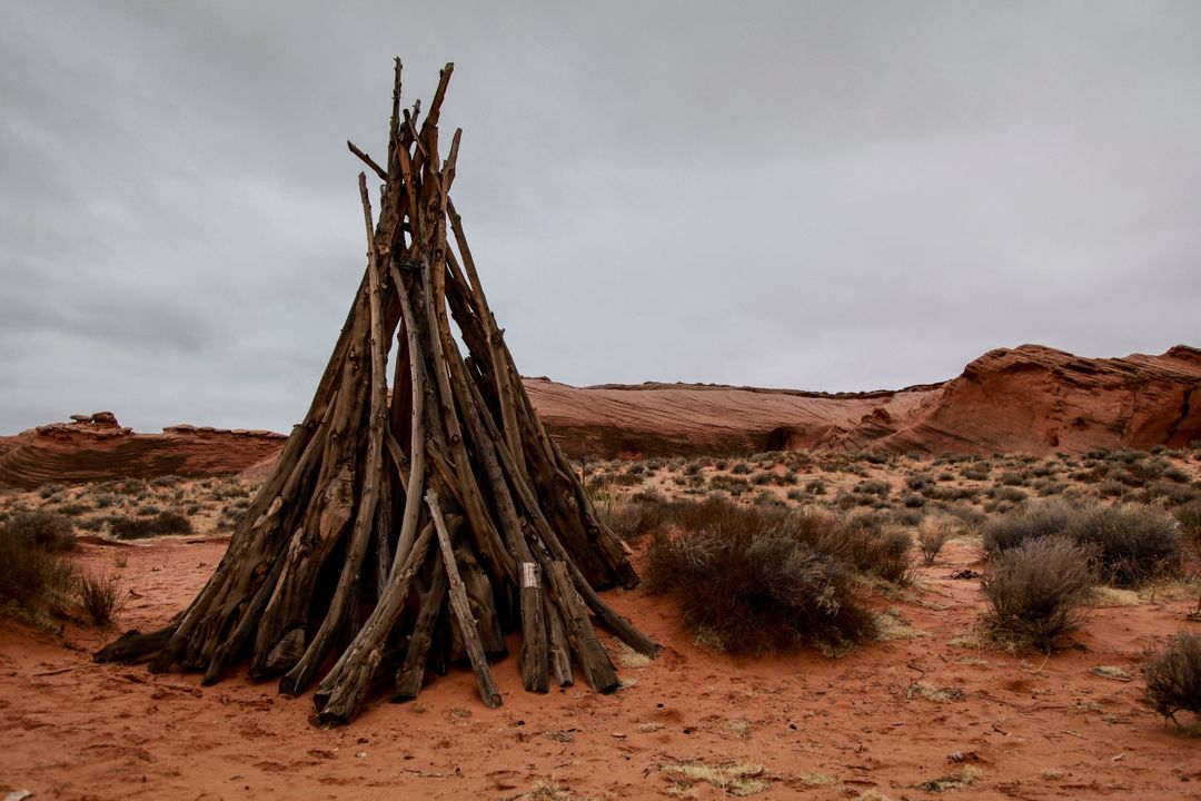 Wooden Teepee in Desert Landscape with Cloudy Sky - Free Images, Stock Photos and Pictures on Pikwizard.com