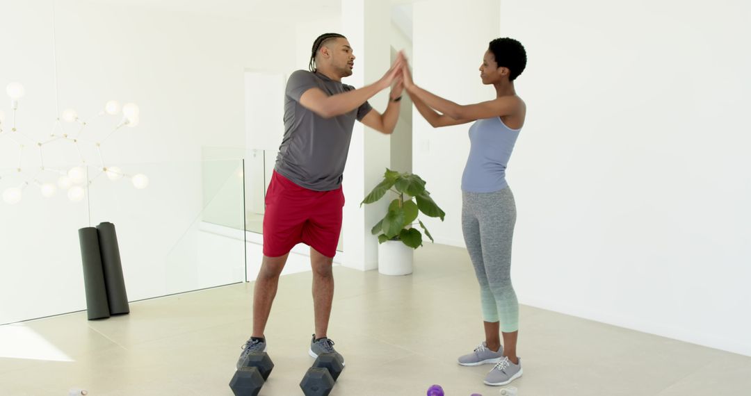 Workout Partners High-Fiving on Hex Dumbbells for Home Exercise Motivation