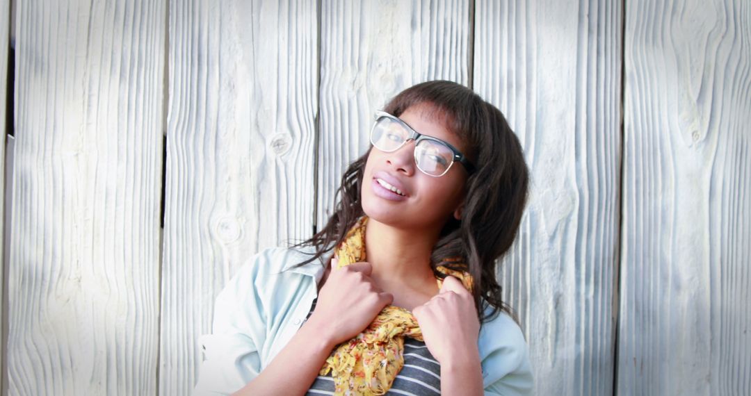 Smiling Woman Wearing Glasses and Striped Shirt Against Wooden Background - Free Images, Stock Photos and Pictures on Pikwizard.com