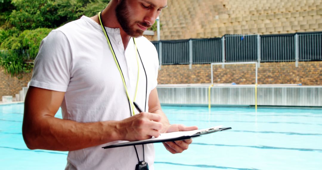 Male Swimming Coach Taking Notes by Poolside - Free Images, Stock Photos and Pictures on Pikwizard.com