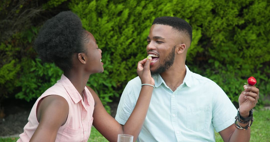 Joyful Couple Enjoying Fresh Strawberries in Garden