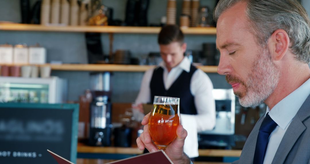 Businessman Enjoying Drink While Deciding on Menu - Free Images, Stock Photos and Pictures on Pikwizard.com