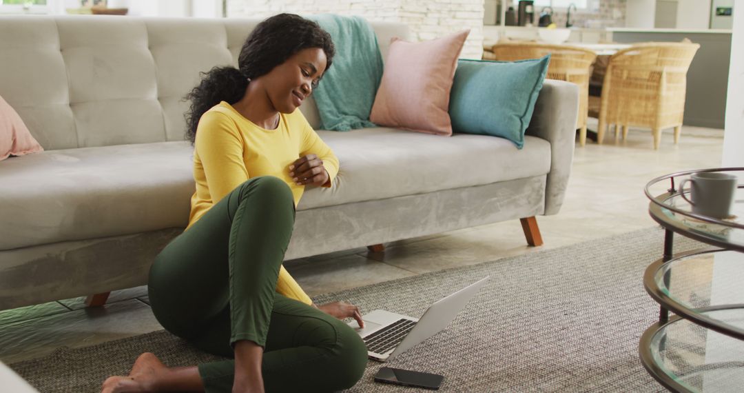 Image of happy african american woman sitting on floor using laptop - Free Images, Stock Photos and Pictures on Pikwizard.com