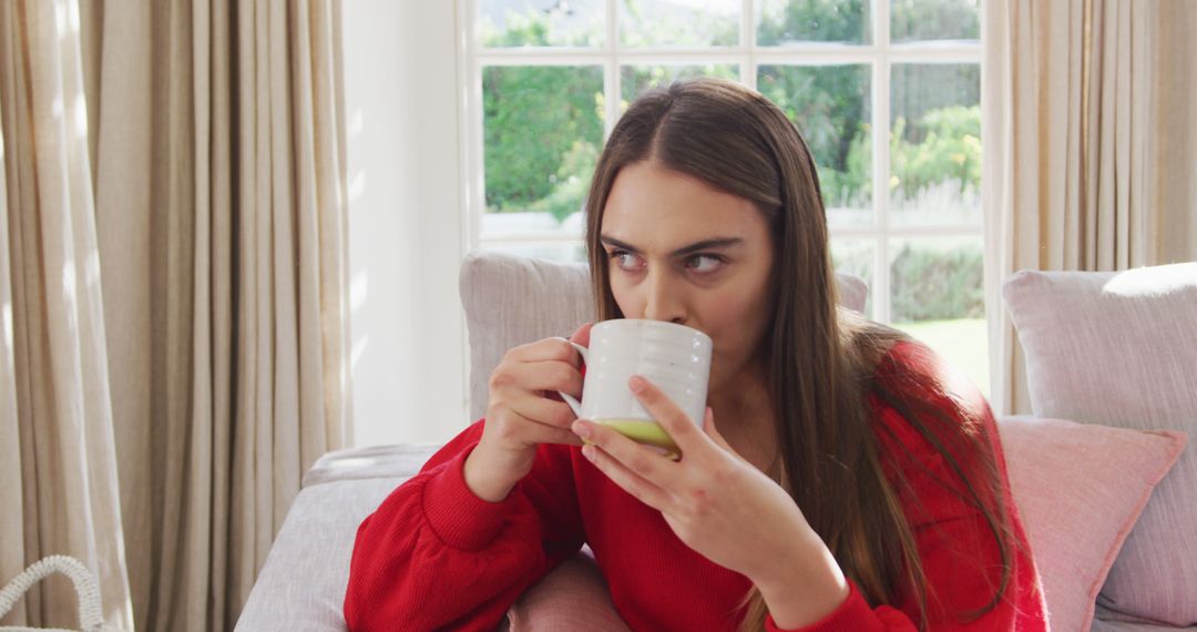 Image of happy caucasian women siting on sofa and drinking coffee - Free Images, Stock Photos and Pictures on Pikwizard.com