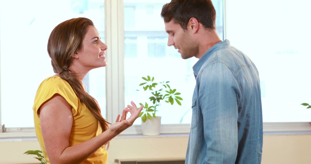 Colleagues Engaged in a Discussion Near Office Window